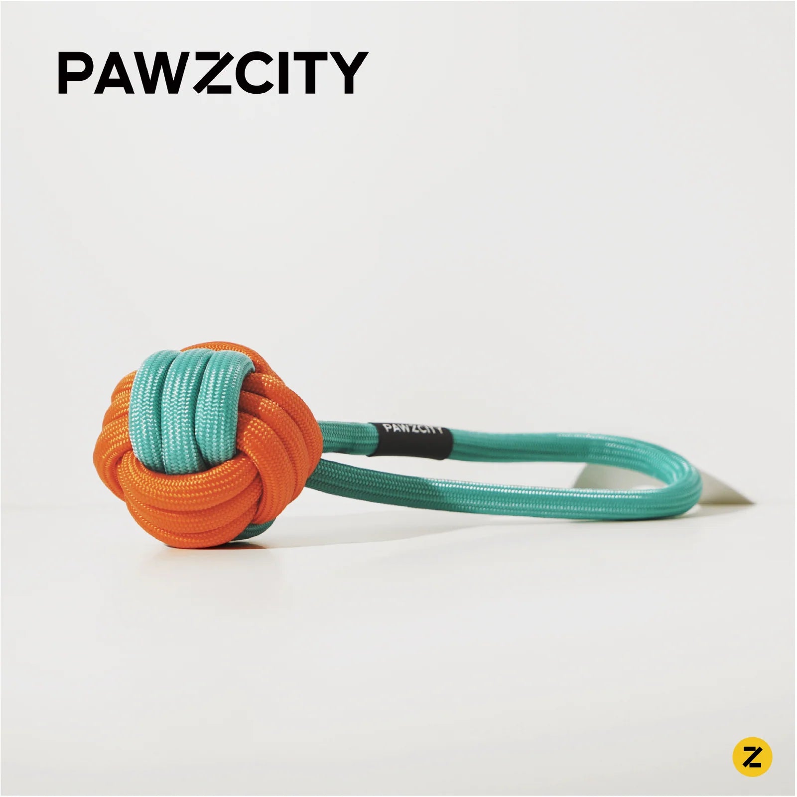 Orange and green knotted rope toy with &