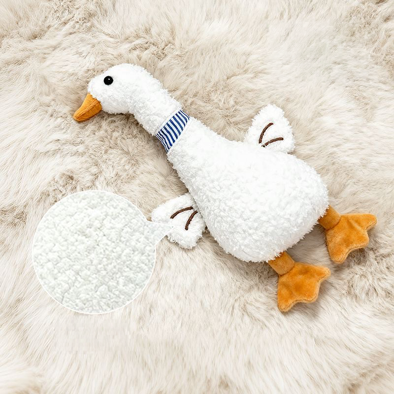 The Leggy Goose dog toy laying on a fluffy rug with a magnified circular graphic highlighting the premium, ultra-soft textured plush fabric designed to be bite-resistant.