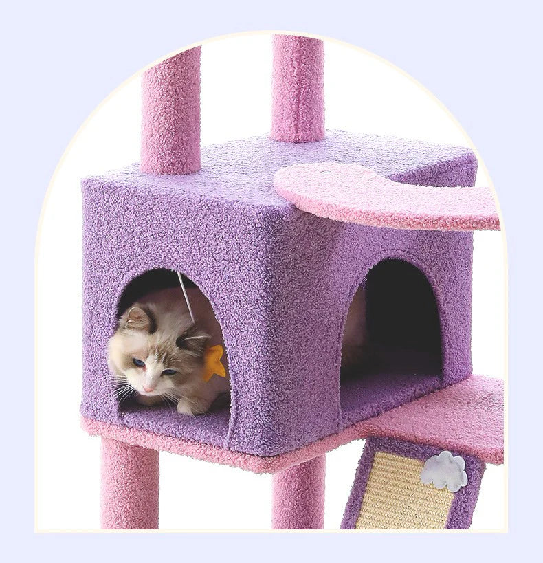 A cat peeking out from the cozy purple retreat condo at the base of the cat tree, showing the built-in ladder and support pillars wrapped in furniture-saving natural sisal rope.
