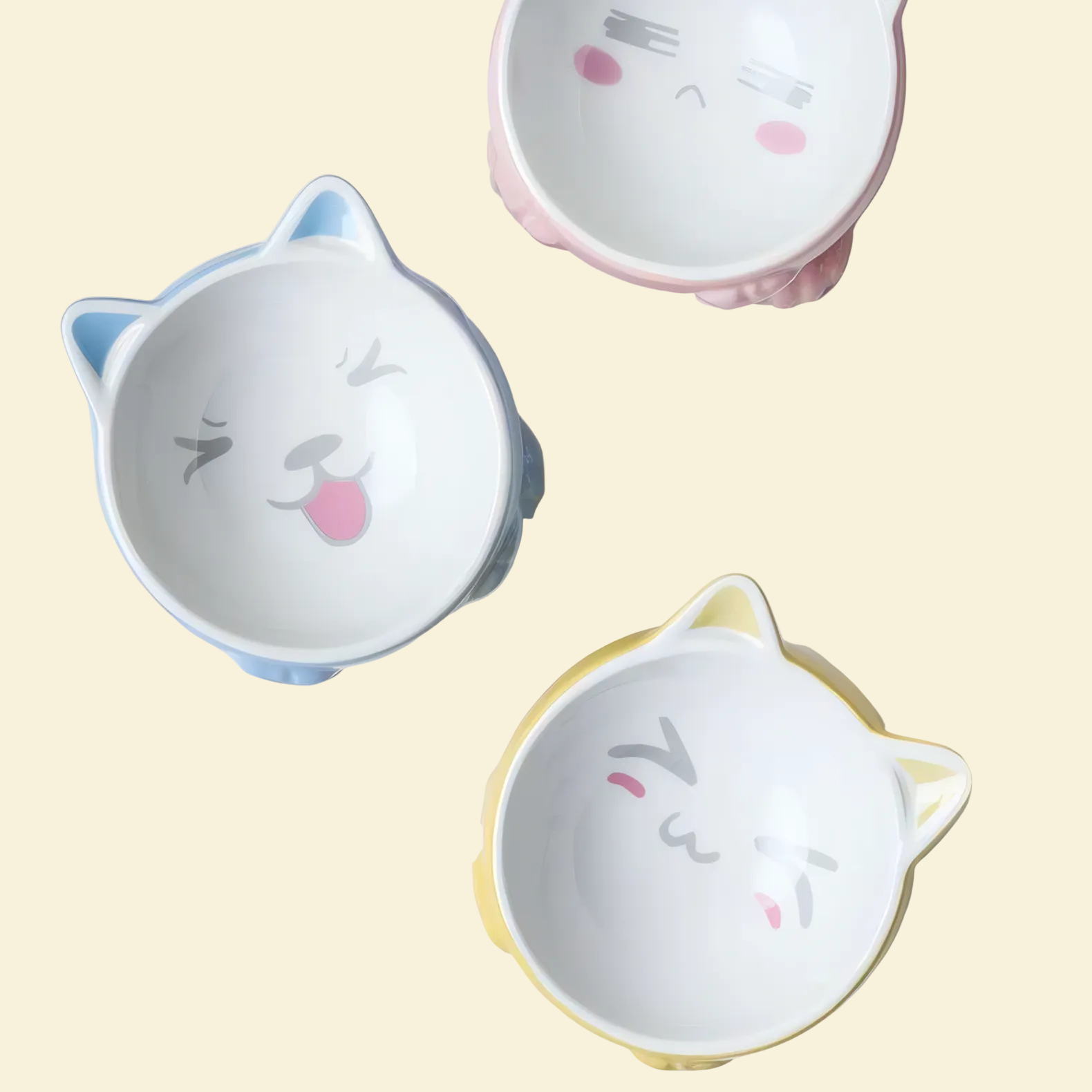 Three cat-shaped ceramic bowls with cartoon faces on a white background