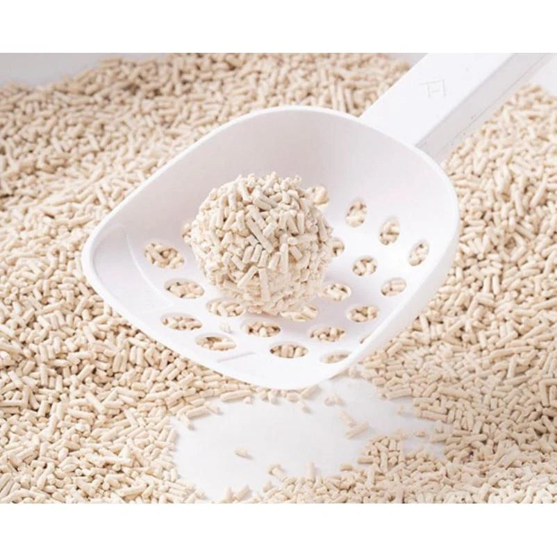 A white litter scoop holding a perfectly round, rock-solid clump formed by the KUNGFU CAT 1.5mm ultra-thin tofu litter pellets.