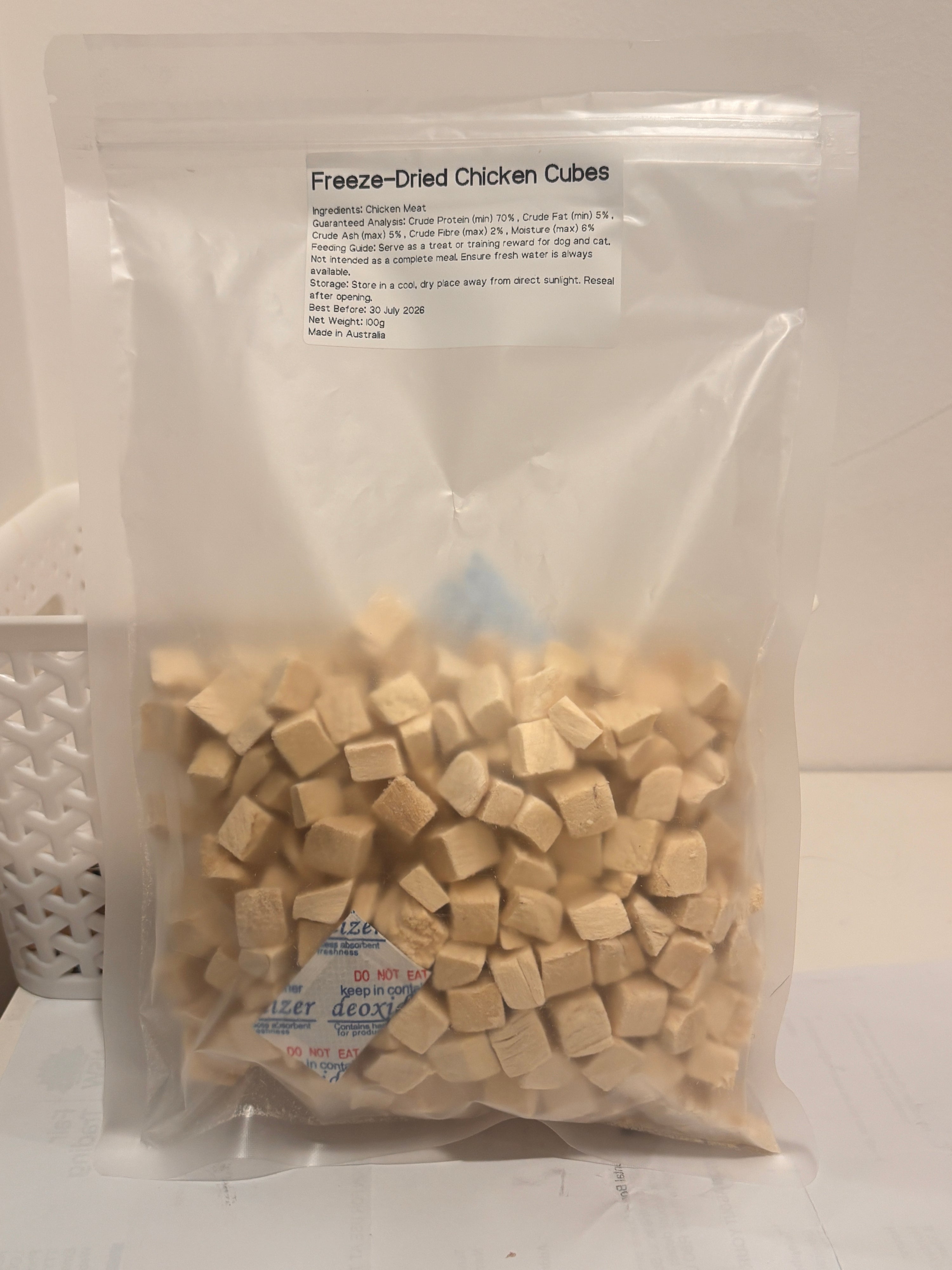 A clear, resealable 100g bag of Freeze-Dried Chicken Cubes, featuring a printed label that details the 100 percent chicken meat formula, 70 percent minimum crude protein, and Australian Made quality.