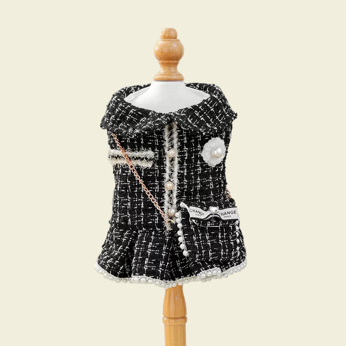 Front view of the black tweed pet dress on a mannequin. Shows the classic collar, pearl button snaps, and premium textured fabric for a high-fashion look