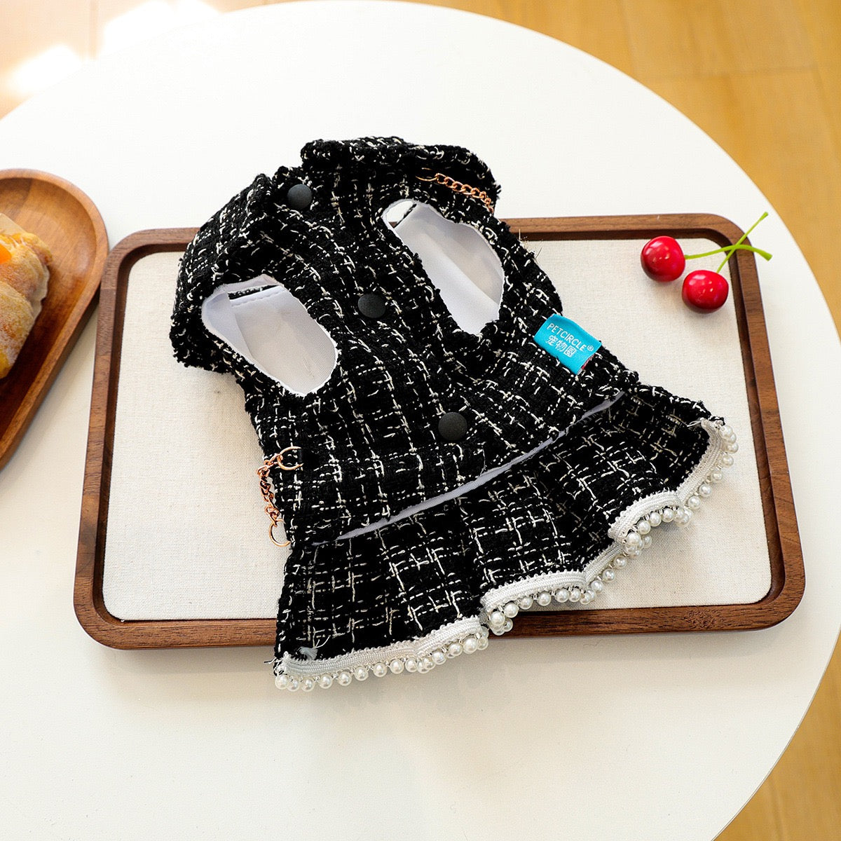 Underside view of the tweed dog dress showing the simple belly-side snap buttons. Designed for stress-free dressing with no zippers to snag fur