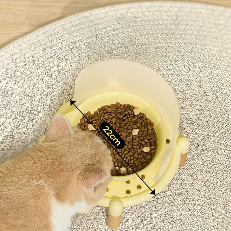 Top view of a cat eating from the Mango Feeder in yellow, showing the 22cm wide whisker-friendly ceramic bowl that prevents whisker fatigue