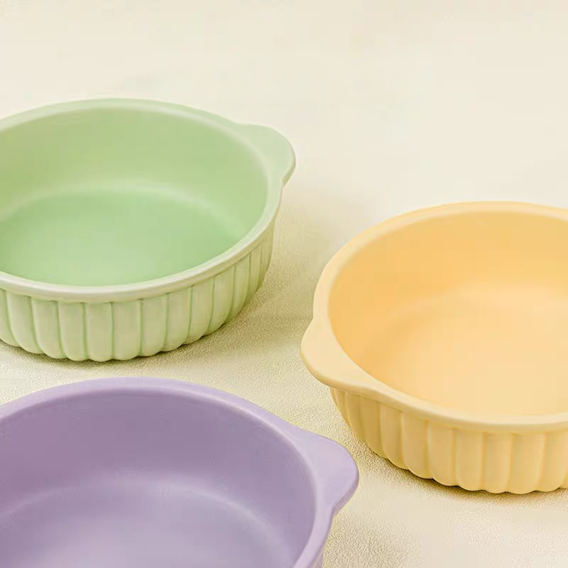Close-up showing the premium high-temperature matte glaze of the green, purple, and yellow Mango pet bowls, featuring charming ribbed details on the exterior.