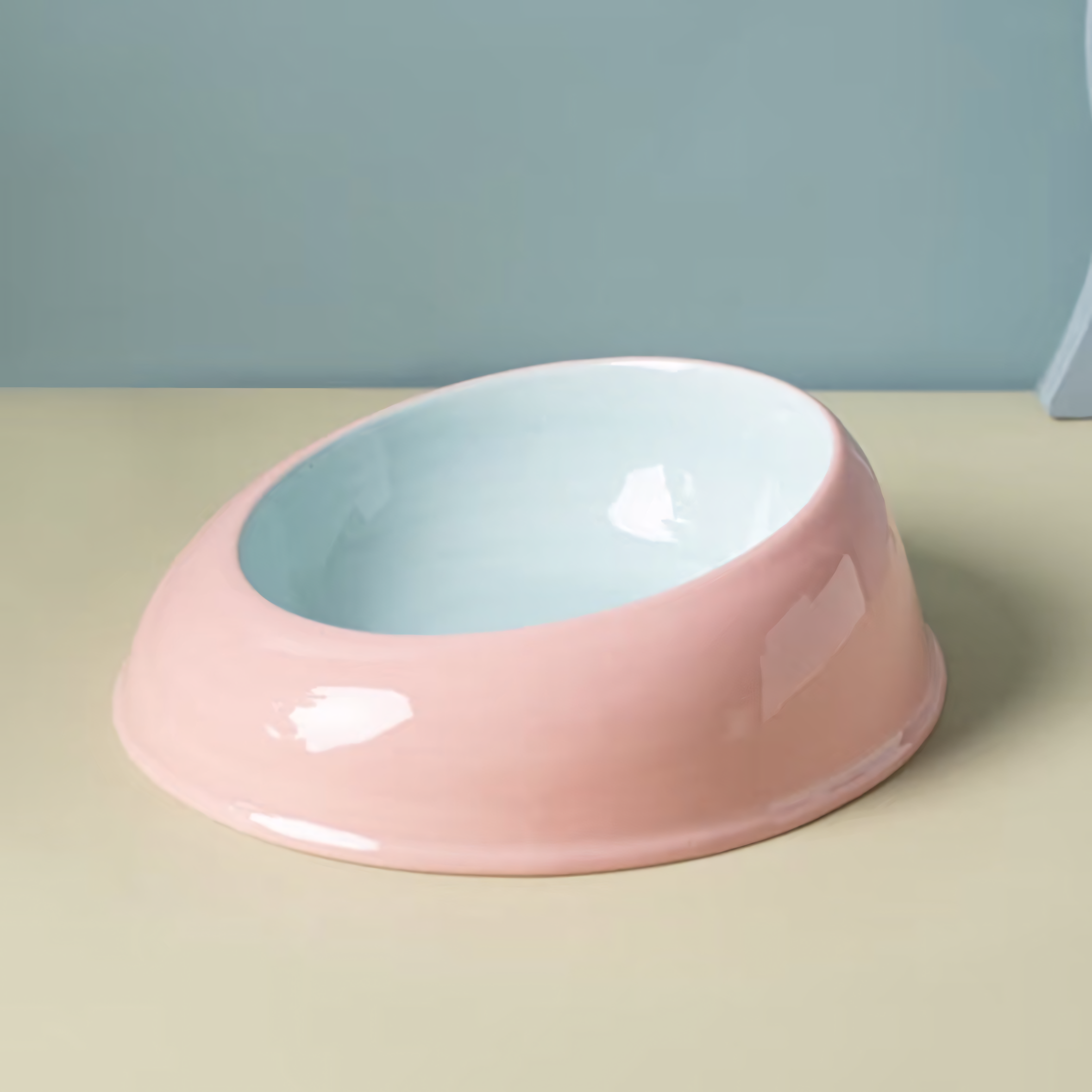 The ultra-glossy Milk Candy ceramic cat feeding dish with a powder blue exterior and soft pink interior, resting on a clean pastel surface.