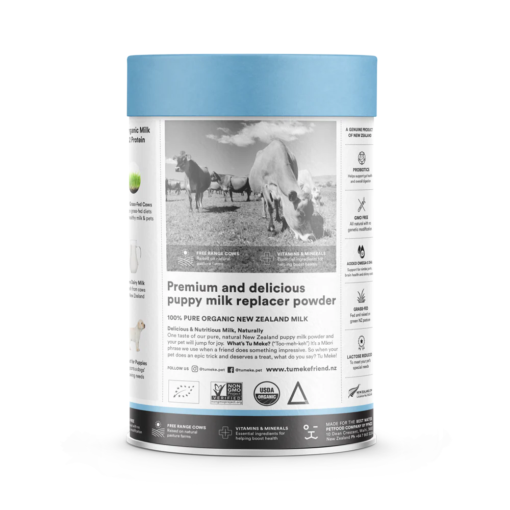 Side view of the TU MEKE FRIEND puppy milk replacer canister, showing a black and white photo of grass-fed cows in a pasture, along with icons highlighting Probiotics, GMO-free ingredients, added Omega-3 DHA, and reduced lactose.