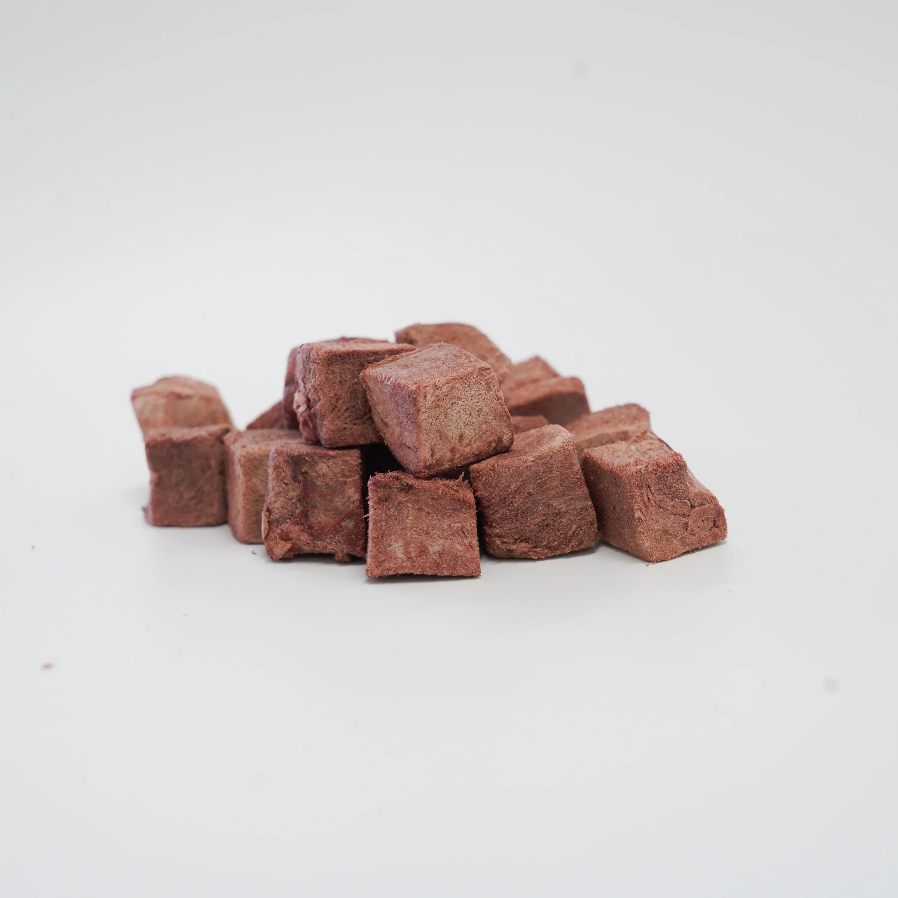 A close-up of RAFA raw freeze-dried Australian emu heart cubes on a white background, highlighting the pure, dense texture of this highly digestible, hypoallergenic novel protein.