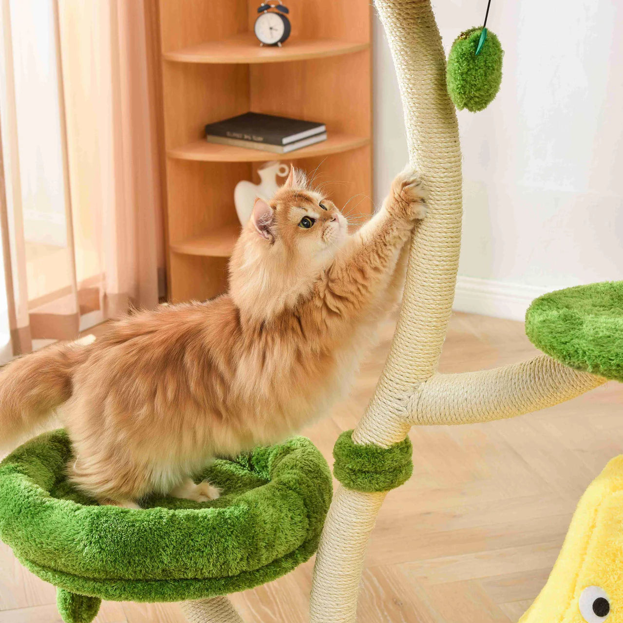 A golden cat stretching to scratch the thick 8cm sisal-wrapped post of the Michu Verde cat tree, while another cat rests in the pear nest. Satisfies natural scratching instincts with strong, reliable support.