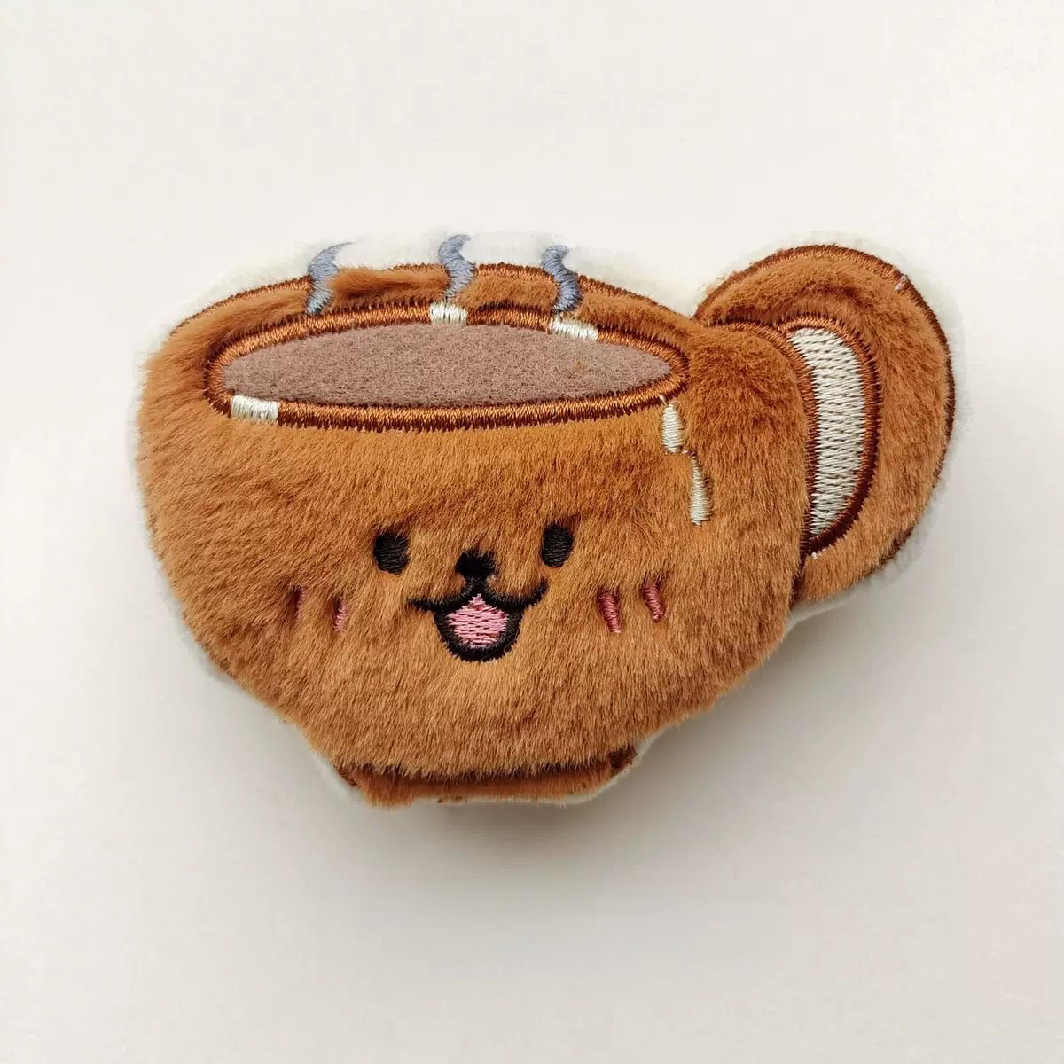 A plush warm coffee cup toy with embroidered steam and a side handle, perfect for a morning "brunch" play session.