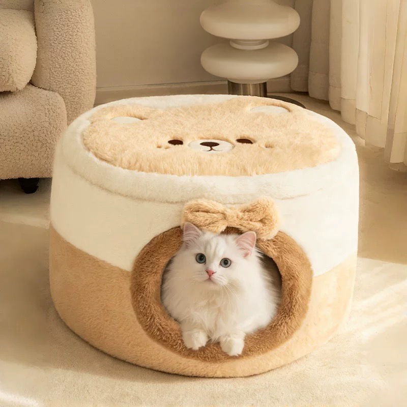 A fluffy white cat resting comfortably inside the enclosed cave configuration of the plush 2-in-1 cat bed, featuring a cute bow above the entrance.