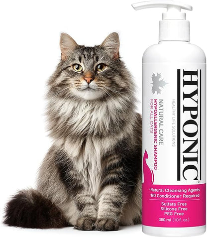Cat sitting next to a bottle of Hyponic cat shampoo on a white background