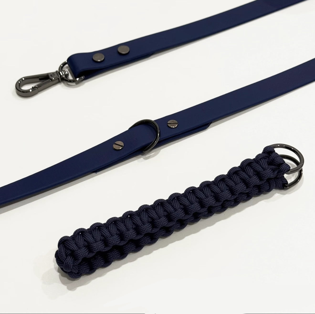 Navy blue dog leash with a braided handle on a white background