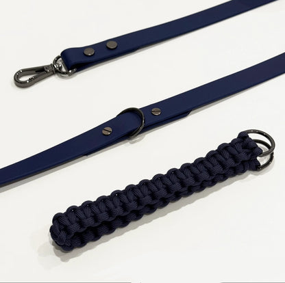Navy blue dog leash with a braided handle on a white background