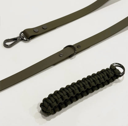 Olive green belt with a paracord keychain on a white background