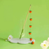 Tangerine style hand-crocheted wool cat teaser wand against a green background.