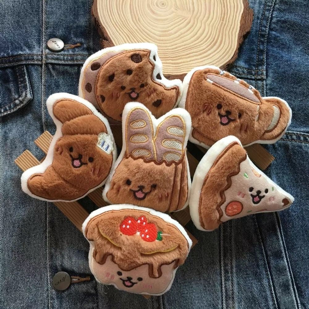 The complete Cafe &amp; Bakery pet toy series displayed on denim fabric, showcasing the artisanal embroidery and cute faces.