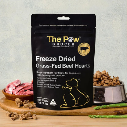 The Paw Grocer 72g Freeze-Dried Beef Hearts treats beautifully displayed on a wooden board next to fresh raw meat and a silver bowl filled with the CoQ10-rich, cardiovascular health-boosting reward.