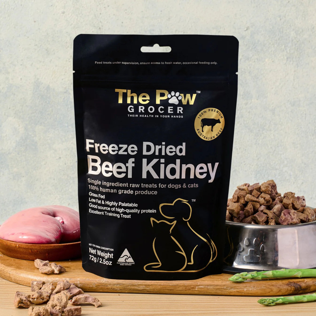 The Paw Grocer 72g Freeze-Dried Beef Kidney treats perfectly displayed on a wooden board next to fresh raw beef kidney and a silver bowl filled with the zero-carb, anti-inflammatory reward.