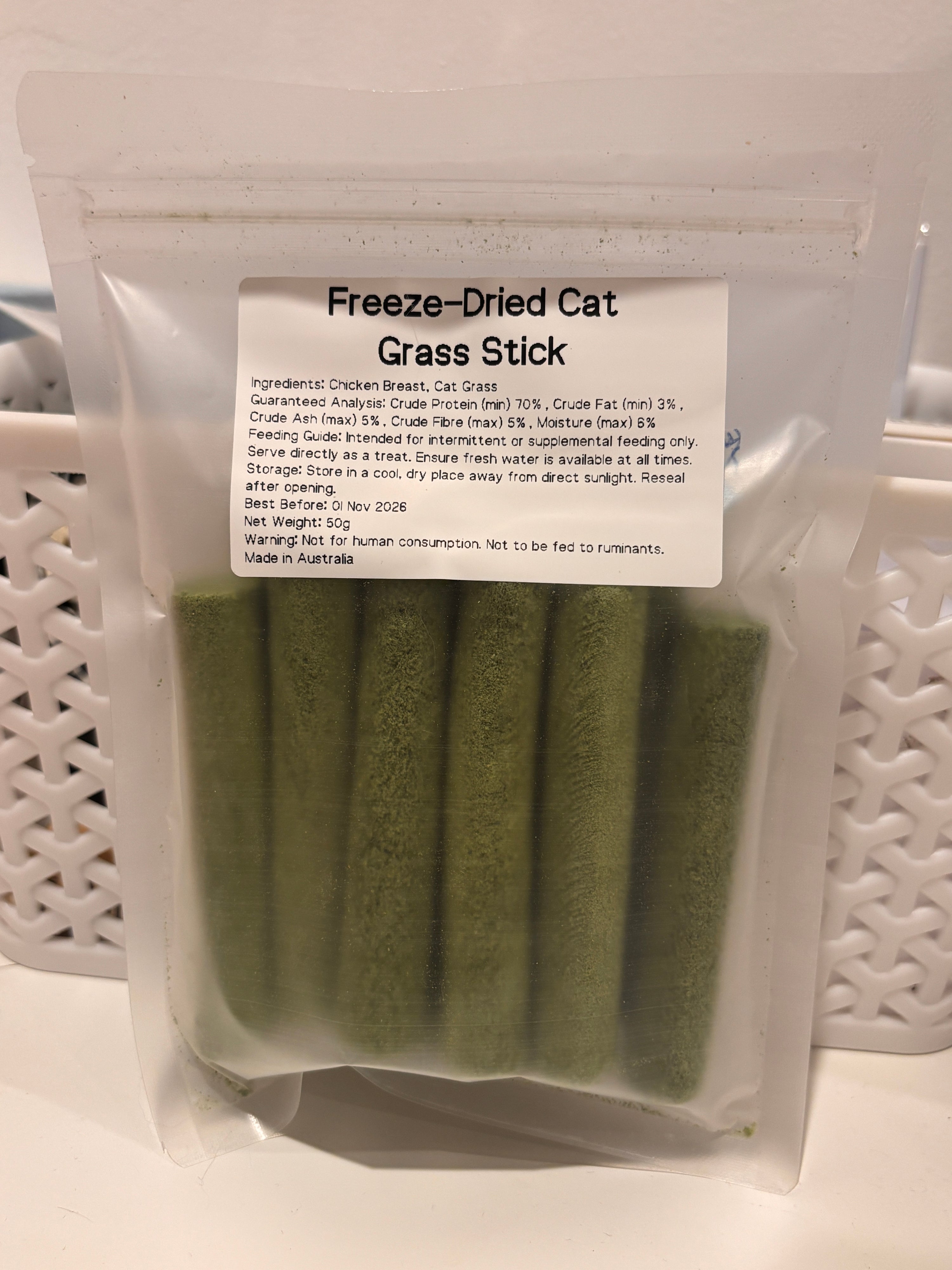 The 50g packaging of Freeze-Dried Cat Grass Sticks, featuring a clear label that details the pure chicken breast and cat grass ingredients, guaranteed analysis, and proudly stating "Made in Australia."