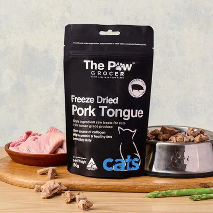 The Paw Grocer 50g Freeze-Dried Pork Tongue treats perfectly displayed on a wooden board next to fresh raw pork tongues and a silver bowl filled with the crunchy, rotational protein reward.