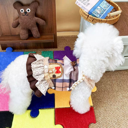 Side profile of a small white dog wearing the boutique Maillard Plaid Princess Dress on a colorful mat. Highlights the exquisite layered floral and lace ruffle skirt and premium tailoring that allows free movement.