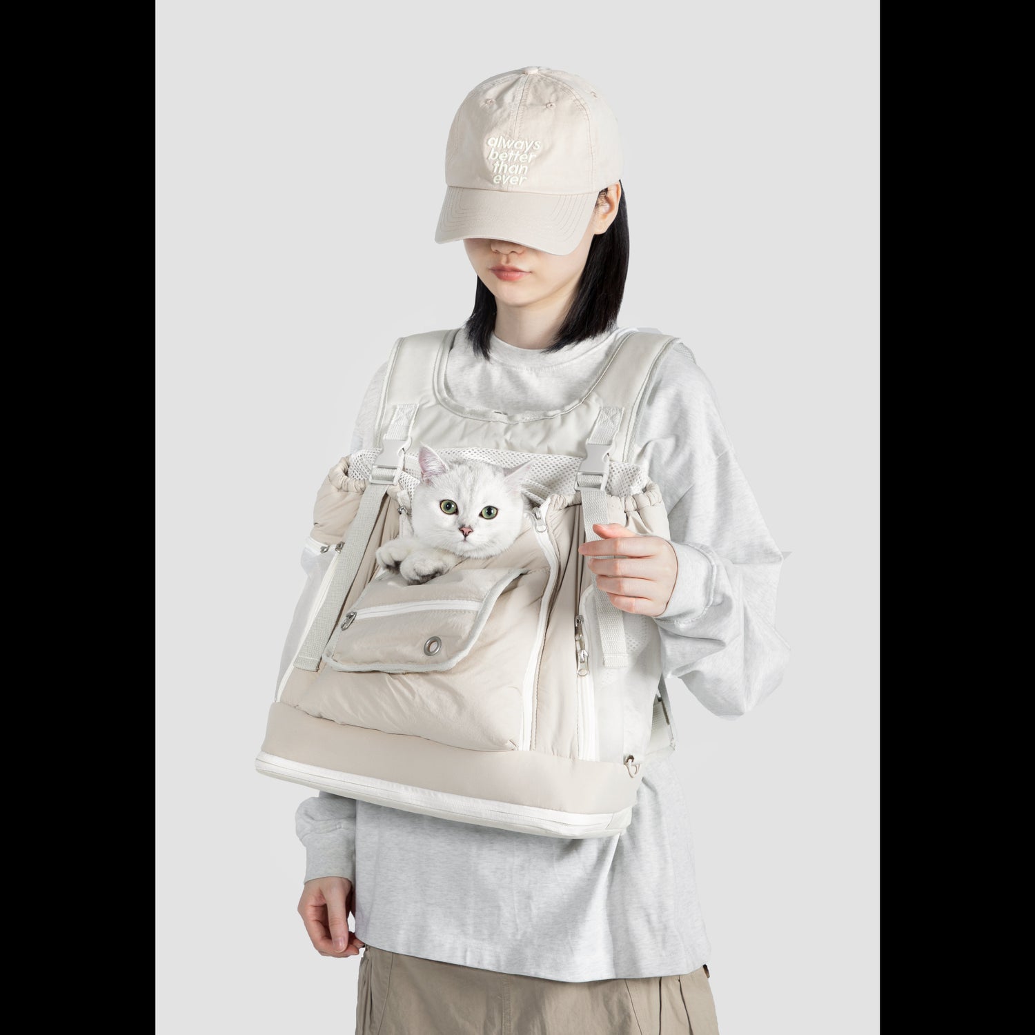 A white cat safely peering out of the breathable LéJoyee front-facing pet carrier backpack, highlighting the adjustable neck opening and large front storage pocket.