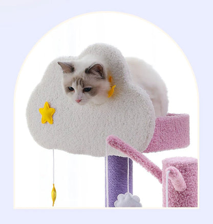 A beautiful cat looking out from the whimsical cloud-shaped top platform of the Tales of the Nebula Cat Tree, featuring dangling moon and star toys for extra fun.