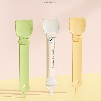 Three Cat Liquid Treat Feeding Spoons in pastel green, cream beige, and orange. The middle spoon securely holds a standard liquid cat treat tube, demonstrating its universal fit.