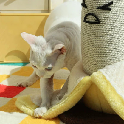 A curious white cat playfully rubbing against the soft, yellow plush banana peels at the base of the quirky cat scratching post.
