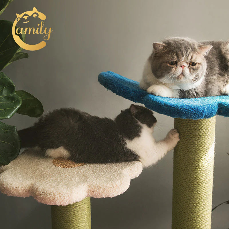 A grey and white cat stretching and vigorously sharpening its claws on the natural sisal rope pillar of the Camily Flower Ladder, while another cat rests on the blue top tier above.