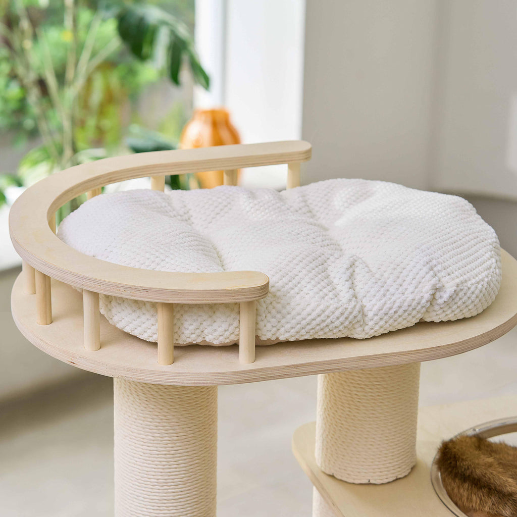 Close-up of the circular top cat perch featuring a soft white cushion and safety wooden railing.