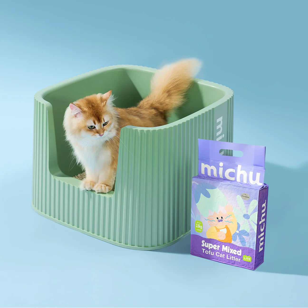 A beautiful golden cat stepping out of a clean green litter box next to a 2.5kg bag of Michu Mixed Tofu Cat Litter Lite, demonstrating a smooth, stress-free transition from traditional clay litter.