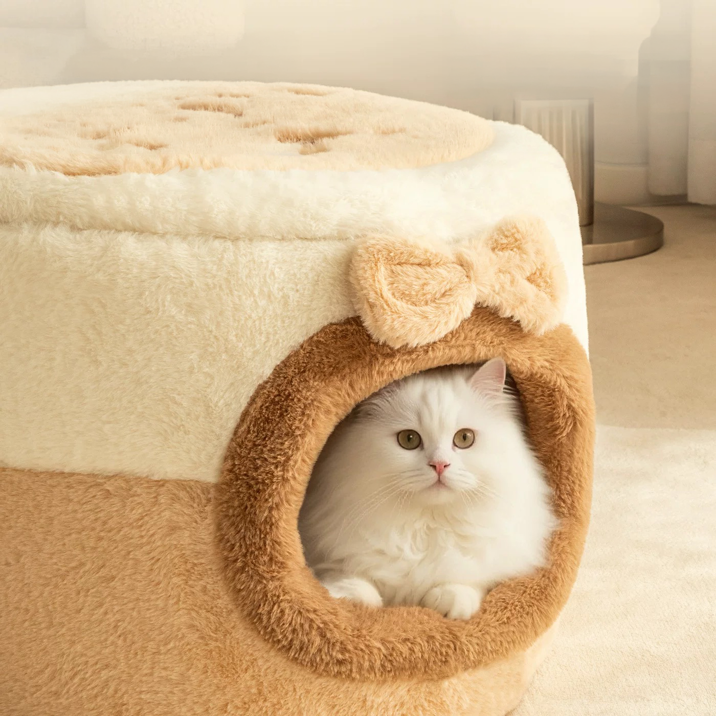 A close-up view of a white cat looking out from the cozy interior of the faux rabbit plush cat cave, highlighting the secure environment and adorable 3D bow detail.