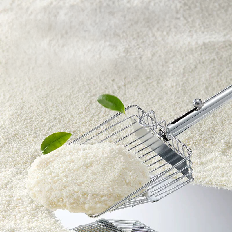 Close-up of a metal scoop lifting a solid, rock-hard clump of Cuihua Xu Cassava Cat Litter. Demonstrates the non-stick formula that prevents litter from gluing to the bottom