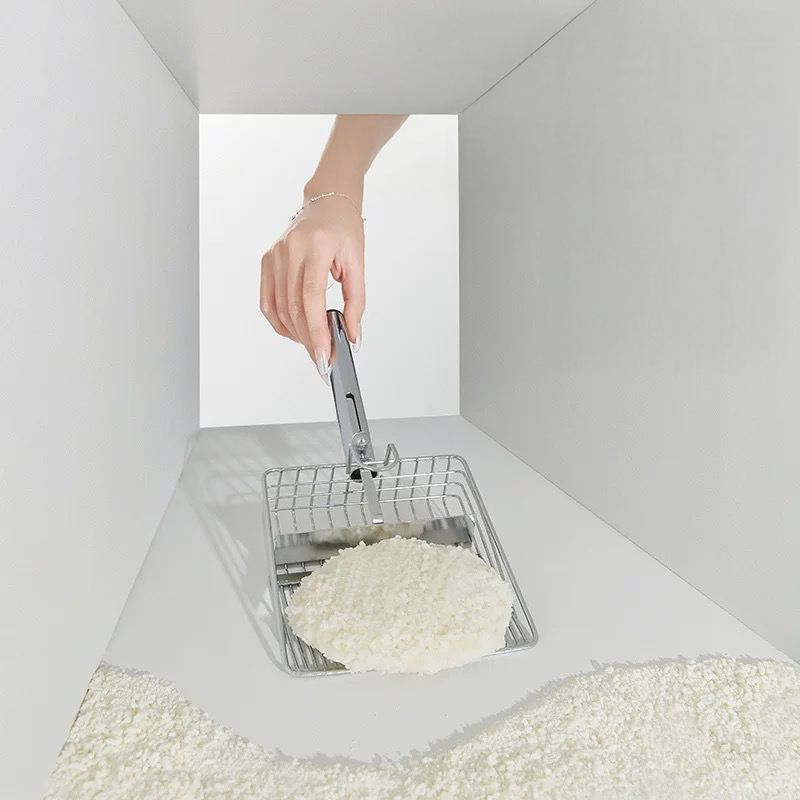 Demonstration of a scoop sliding effortlessly underneath a clump in the litter box. Cuihua Xu natural litter ensures a fresh, dust-free cleaning ritual without scraping