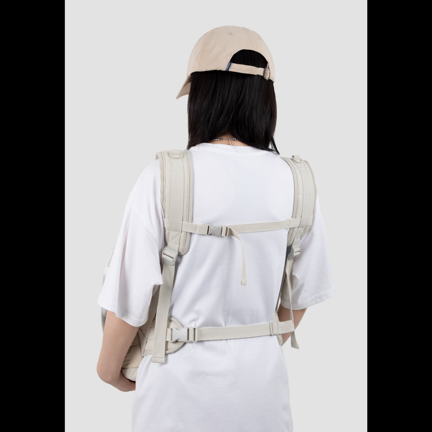 Back view of a pet owner wearing the ergonomic pet front carrier, showcasing the narrow-shoulder friendly straps and secure cross-body buckle for optimal lumbar support.