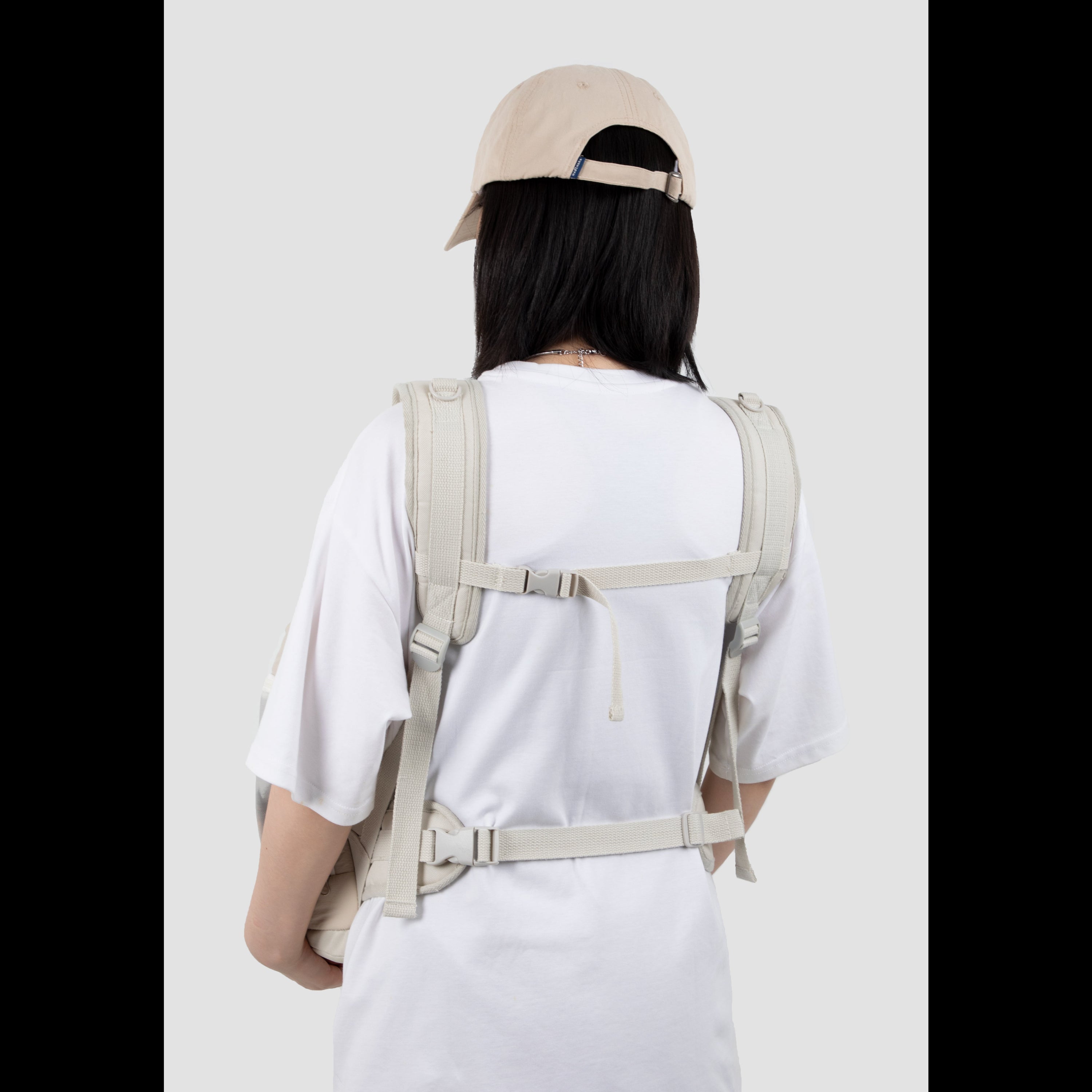 Back view of a pet owner wearing the ergonomic pet front carrier, showcasing the narrow-shoulder friendly straps and secure cross-body buckle for optimal lumbar support.