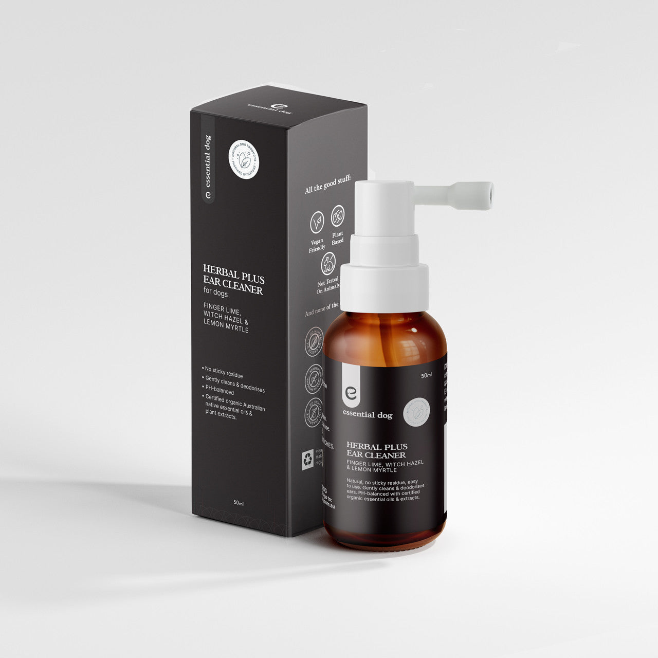 The 50ml amber glass bottle of Essential Dog Herbal Plus Ear Cleaner with an extended white spray nozzle, displayed next to its sleek black packaging box.