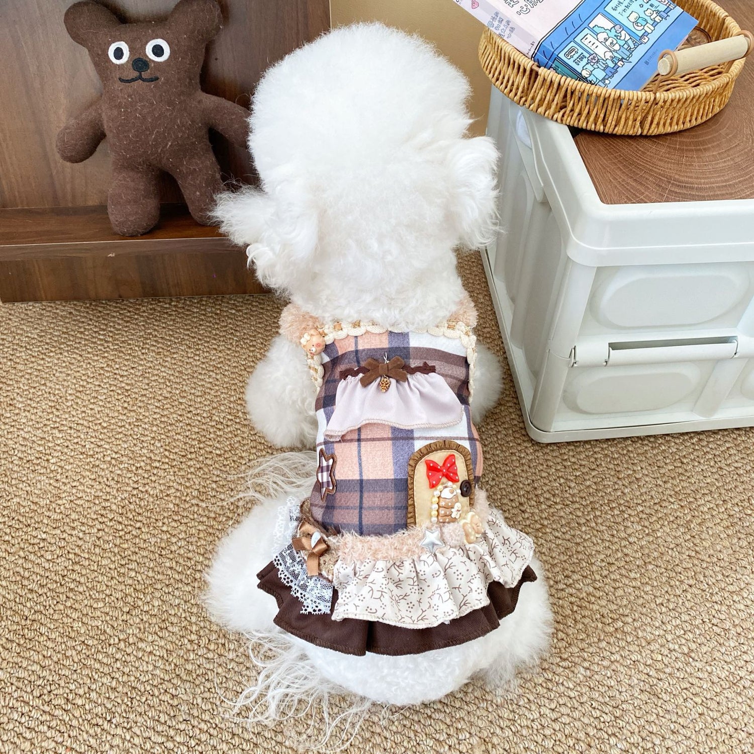 Back view of a white Bichon wearing the Maillard Plaid Dog Dress. Detailed shot of the lavish embellishments, including a sweet back-pocket applique with a red bow, plaid bodice, and lace trims.