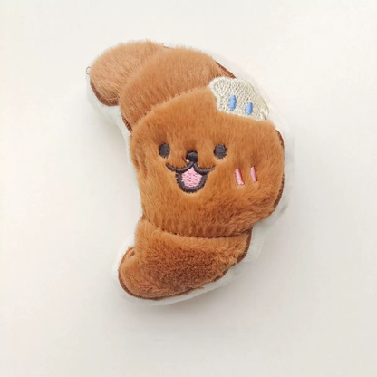 A petite 9.5cm flaky croissant plush toy with a soft brown texture and a tiny butter embroidery on the side.