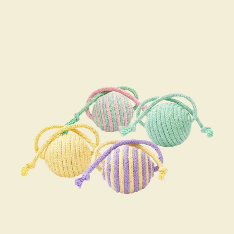 Four pastel striped sisal cat toy balls with attached cotton ropes in different vibrant color combinations, isolated on a white background.