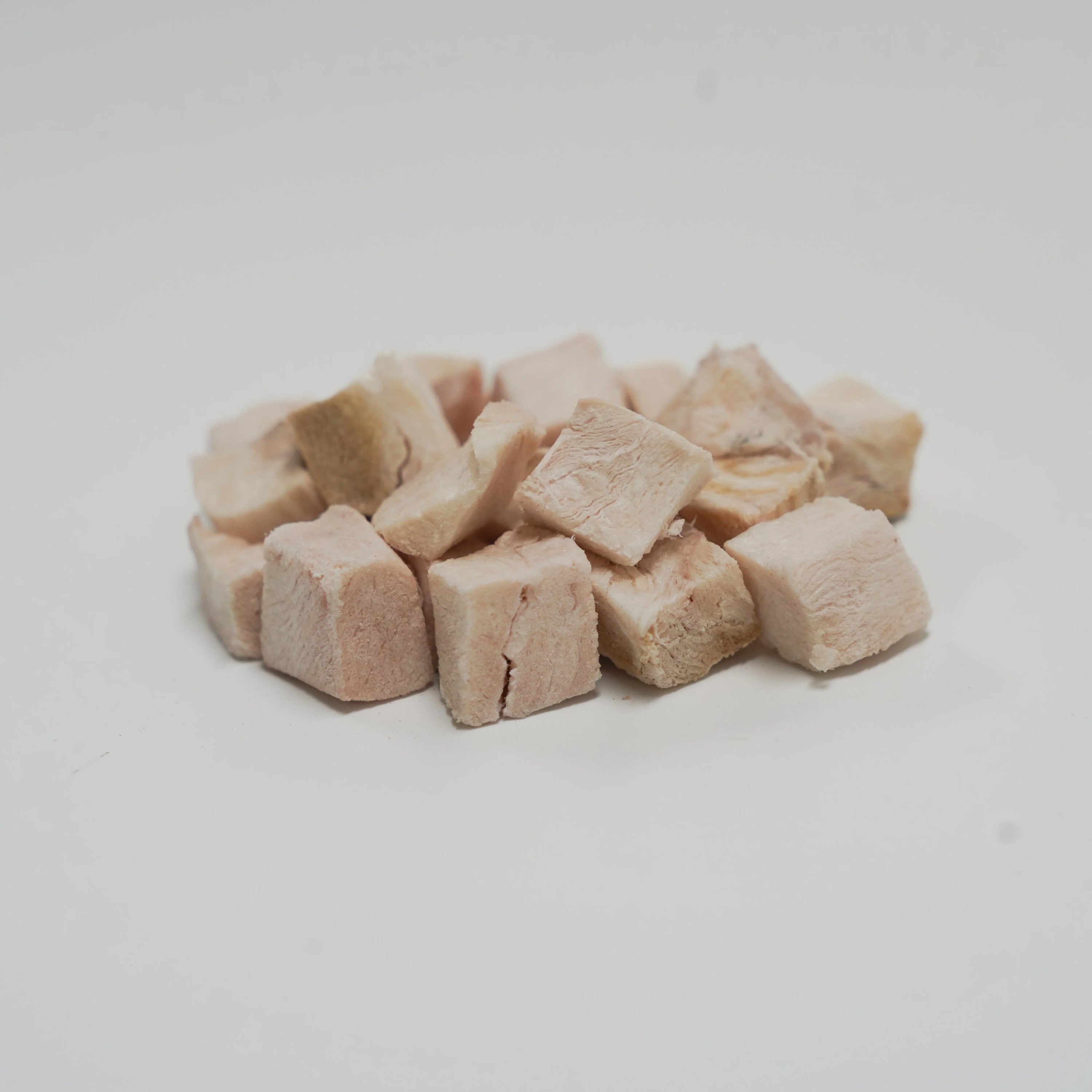 A close-up pile of Rafa Raw freeze-dried crocodile steak cubes. Light, neutral-flavored white meat single-ingredient treats perfect for fussy eaters and pets with severe food allergies.