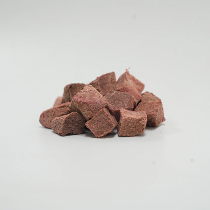 A close-up pile of Rafa Raw freeze-dried emu steak cubes. Dark, chewy, single-ingredient raw red meat treats perfect for picky eaters and pets with food allergies.