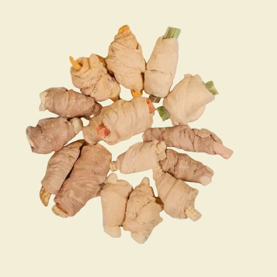 A top-down view of various freeze-dried mixed wrapped bites, showcasing premium chicken and duck breast wrapped around superfoods like okra, pumpkin, and cheese.