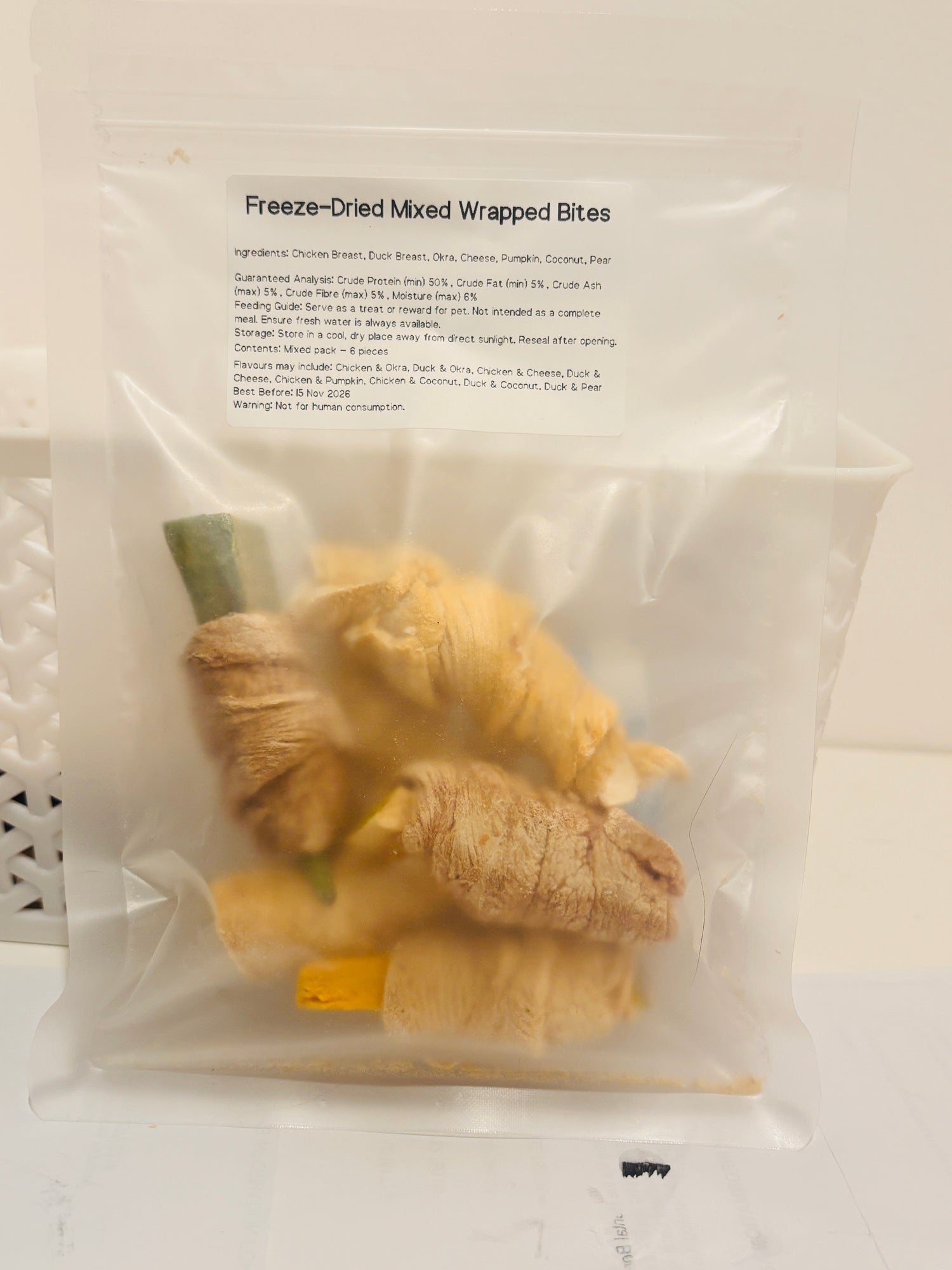 A clear, resealable bag containing a 6-piece mixed pack of Freeze-Dried Wrapped Bites, featuring a printed label that details the meat and superfood ingredients, feeding guide, and a minimum of 50 percent crude protein.