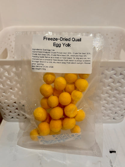 A clear, resealable 50g bag of Freeze-Dried Quail Egg Yolk pet treats, featuring a printed label that details the 100% single-ingredient formula, feeding guide, and guaranteed analysis with a minimum of 35% crude protein.