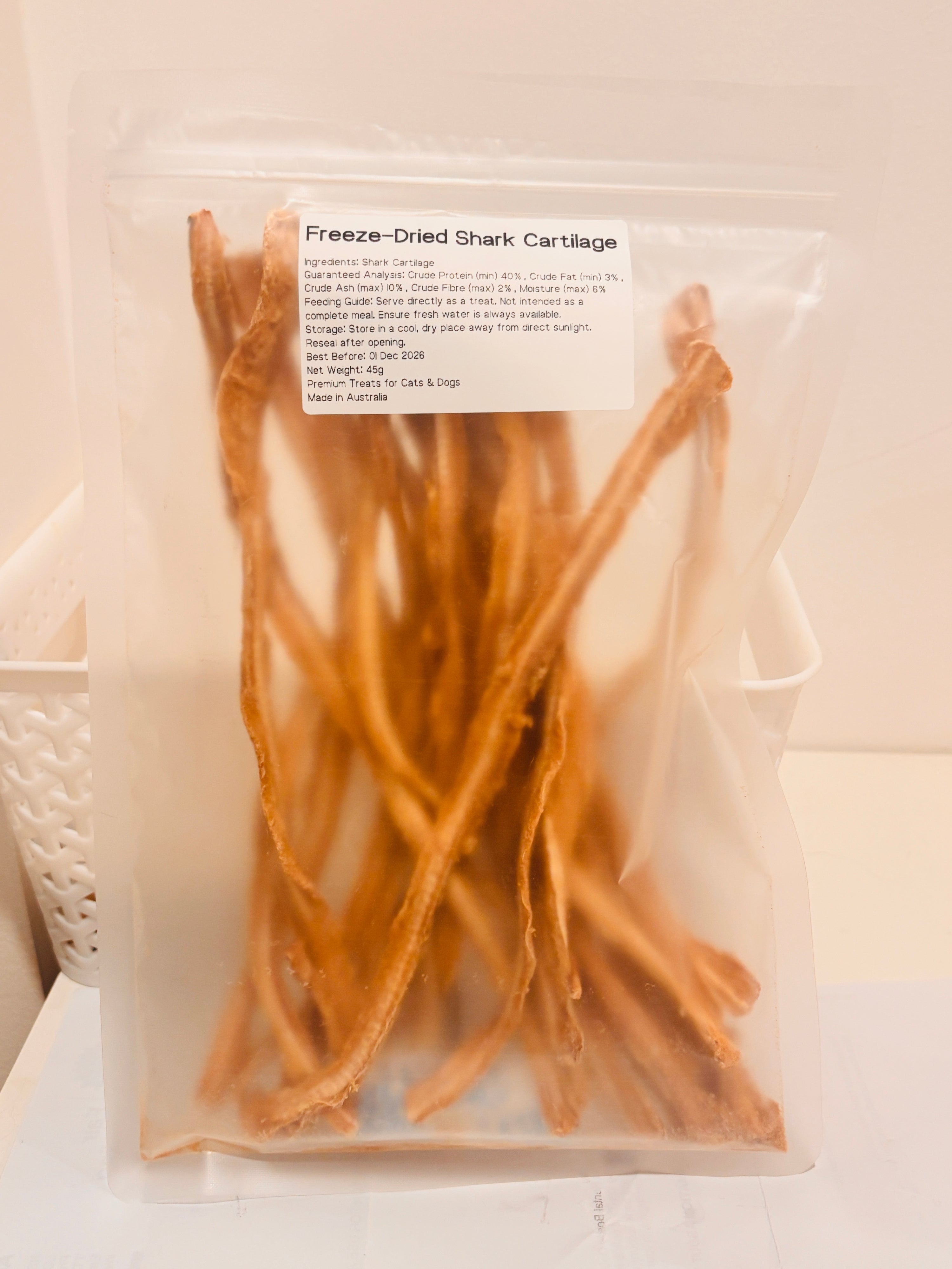A clear, resealable 45g bag of Freeze-Dried Shark Cartilage treats, featuring a printed label that details the 100 percent single-ingredient formula, feeding guide, and Australian Made quality.
