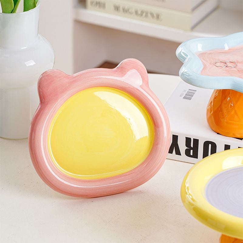 Close-up of the glossy pink and yellow Teddy Bear elevated cat bowl. Crafted from premium, non-porous ceramic that naturally resists bacteria and prevents feline chin acne.